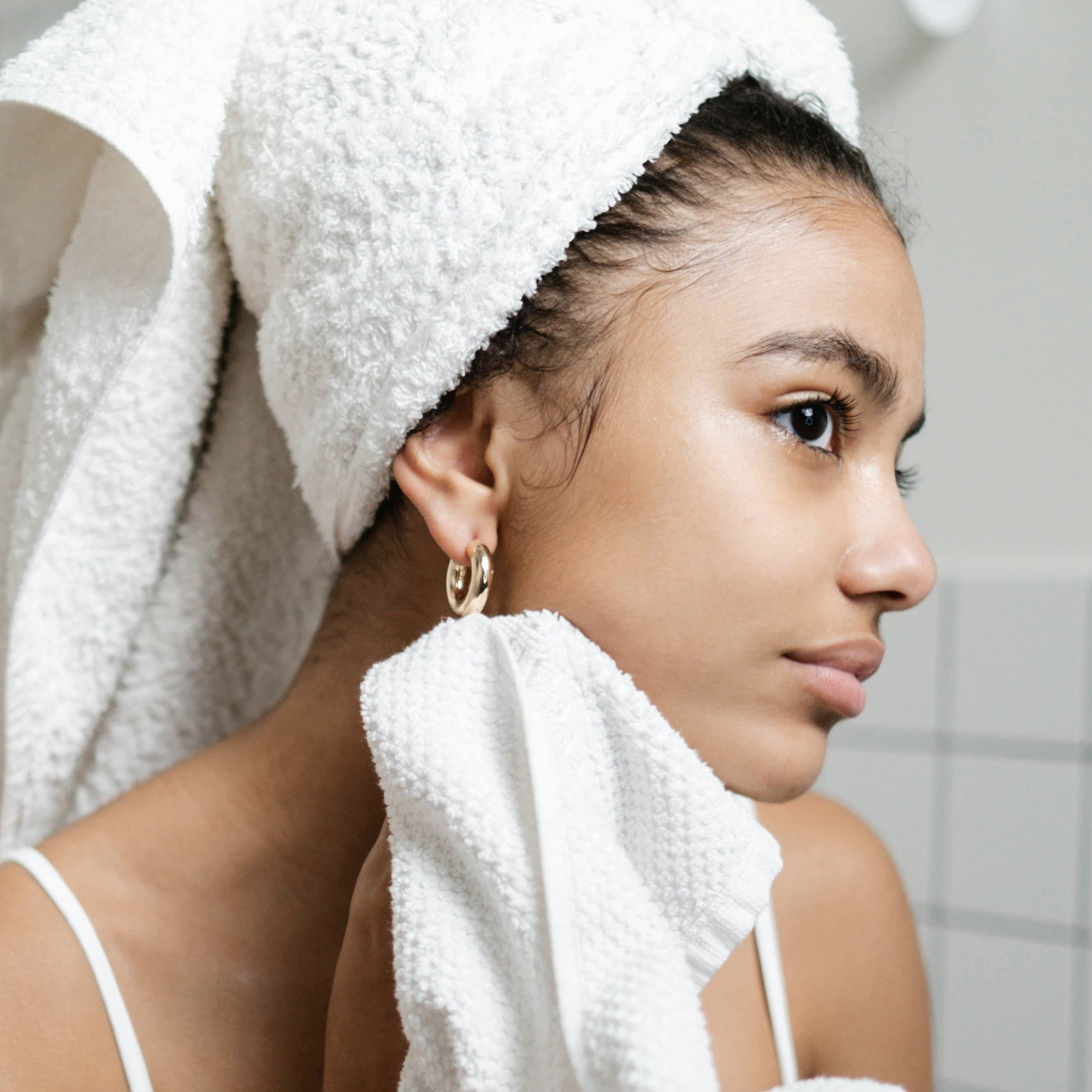A woman with radiant, even-toned skin and a natural, glowing complexion smiles warmly at the camera. Her skin appears smooth and flawless, showcasing the kind of results semi-permanent foundation and contouring can help achieve. This image reflects confidence, healthy skin, and the subtle enhancement offered by semi-permanent makeup treatments.