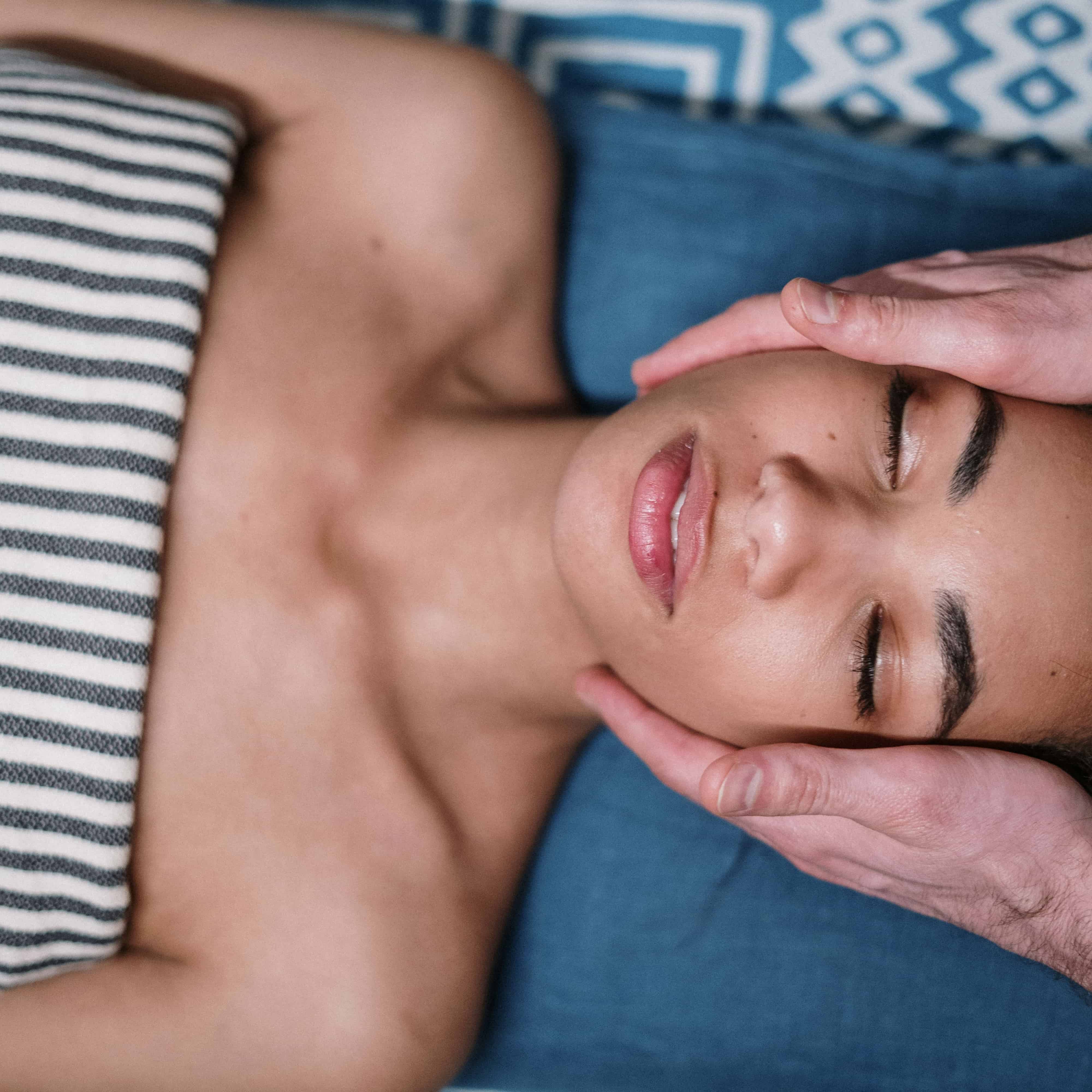 A woman receives a relaxing facial treatment at a medspa, eyes closed and wrapped in a striped towel. The soothing experience reflects the shift from outdated procedures to more modern, holistic aesthetic treatments in 2025. This image captures the calming, results-driven approach of today’s medspa trends.