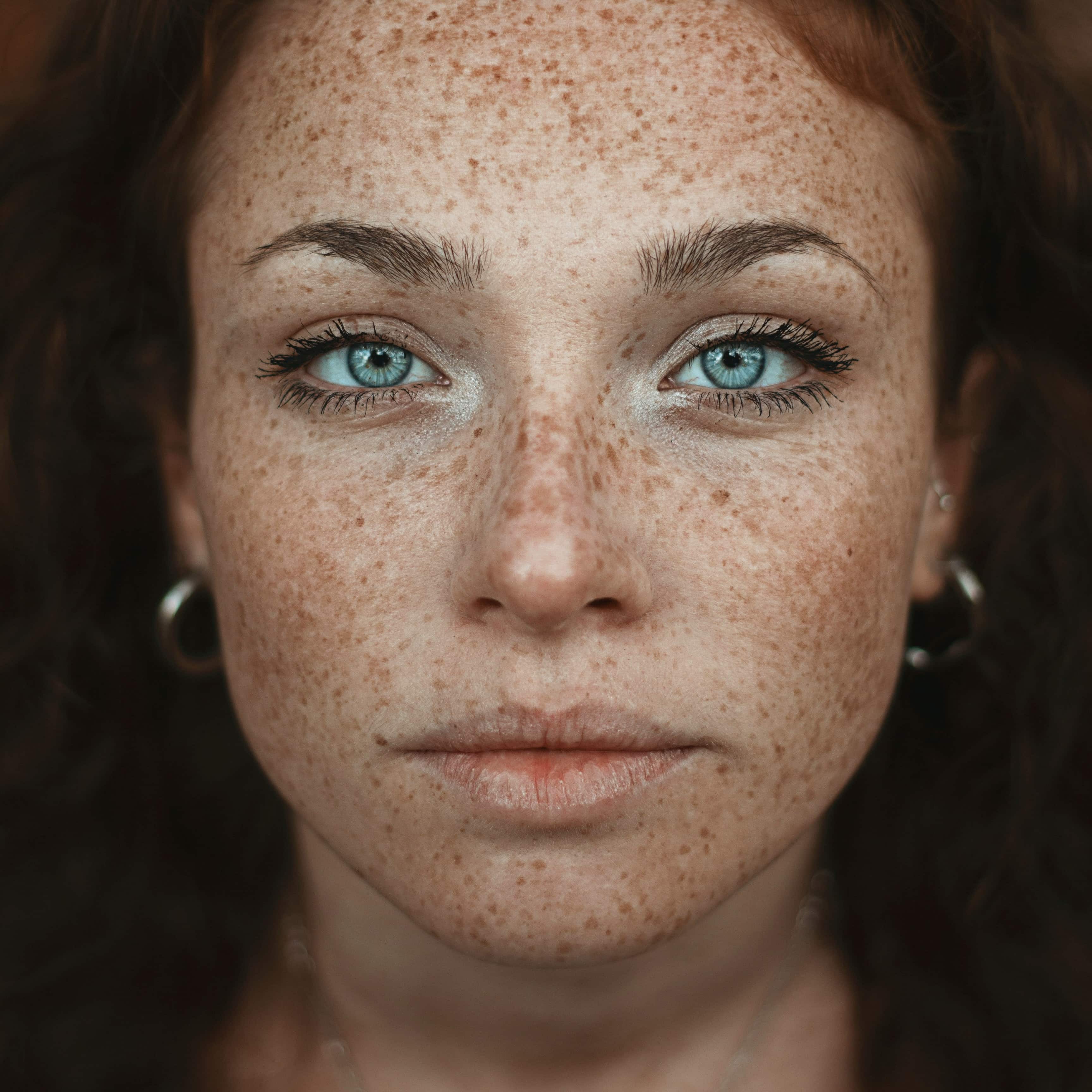 Close-up of a woman with glowing, youthful skin and a natural smile, showcasing the results of advanced skin rejuvenation treatments using biosomes and exosomes. Perfect complexion, long lashes, and smooth texture highlight the anti-aging effects of regenerative skincare technology.