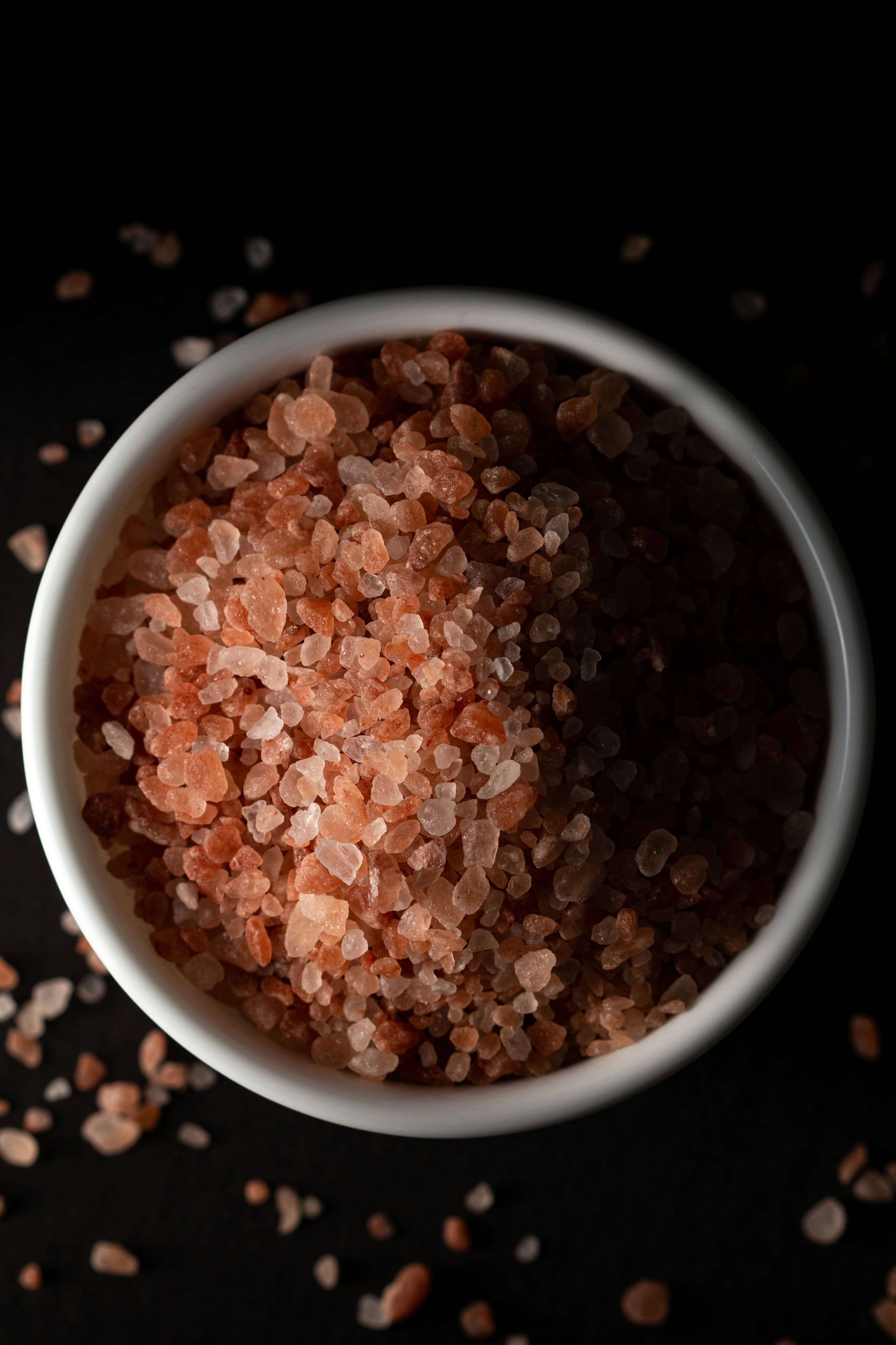 A serene and natural setting featuring a bowl of Himalayan pink salt, known for its therapeutic properties. The pink salt, with its distinctive color due to trace minerals, is often used in salt therapy rooms to promote relaxation and respiratory health. The bowl is placed on a simple, natural surface, evoking a sense of calm and tranquility, reflecting the peaceful ambiance of a salt therapy session. Christina Rumpf